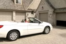 Woman in her car in front of her 4-door garage